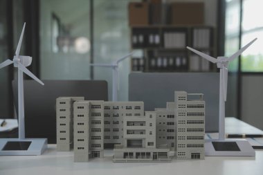 Tablete yakın çekim, Mühendisler tableti elleriyle işaret ediyorlar. Rüzgar ve güneş enerjisiyle yenilenebilir enerji kullanımını ortaklaşa tasarlamak için. Yenilenebilir enerji kullanma kavramı.