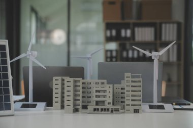 Tablete yakın çekim, Mühendisler tableti elleriyle işaret ediyorlar. Rüzgar ve güneş enerjisiyle yenilenebilir enerji kullanımını ortaklaşa tasarlamak için. Yenilenebilir enerji kullanma kavramı.