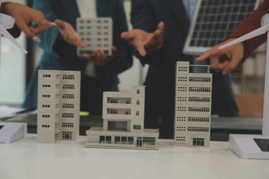 Tablete yakın çekim, Mühendisler tableti elleriyle işaret ediyorlar. Rüzgar ve güneş enerjisiyle yenilenebilir enerji kullanımını ortaklaşa tasarlamak için. Yenilenebilir enerji kullanma kavramı.