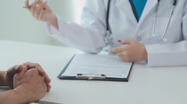 Hastanedeki kanepede otururken, hasta doktor ellerinin baş parmaklarını göstermesi.