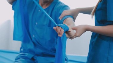 Üniformalı genç doktor klinikte fizik tedavi görüyor..