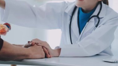 Doktor ve hasta hastanede masada oturuyor.