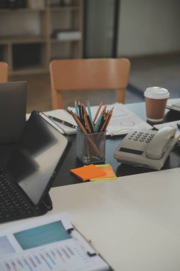 İş ekibi toplantısı yeni bir başlangıç projesi üzerinde çalışıyor, verileri tartışıyor ve analiz ediyor çizelgeler ve grafikler. Dijital tablet, hesap makinesi, dizüstü bilgisayar kullanımı, iş finans ve muhasebe kavramı.