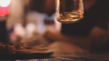 Bulanık camlı ahşap bir masanın üzerinde bir kadeh şarabı kapat.