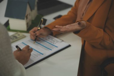 Discussion with a real estate agent, House model with agent and customer discussing for the contract to buy, get insurance or loan real estate or property.