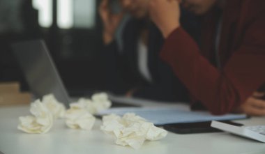 Stresli ofis çalışanı yöneticisinin iş görüşmelerinde iş arkadaşlarıyla çözmeleri gereken sorunlar hakkında baş ağrısı çekmesi. İş stresi ya da migren konsepti.