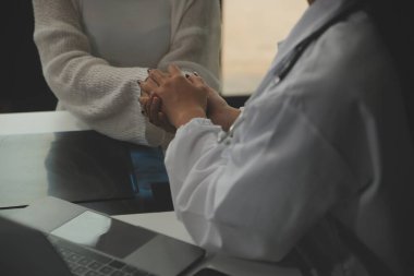 Asyalı kadın doktor hastanedeki kadın hastaya umut veriyor ve onu cesaretlendiriyor. Gülümseyen doktor kadın hasta omzuna dokunuyor. Bakımı ve yardımı için. Desteklenen ve cesaretlendirilen