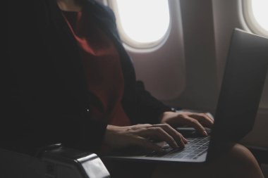 Sarışın kadın turist gelen bildirim netbook ile uçak koltuğunda oturan Smartphone cep telefonu ile kontrol. Genç işkadını paylaşmak medya telefonu dizüstü bilgisayar üzerinde uçak uçuş sırasında