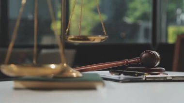 Adalet ve hukuk. Hukuk ve hukuk bürosu kavramı. Ofis masasının arka planında kopya alanı olan kitaplarla tokmak