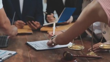 Bir grup iş adamı ofiste belgeleri, hukuki adalet kavramını ve hukuki hizmetleri tartışıyor.