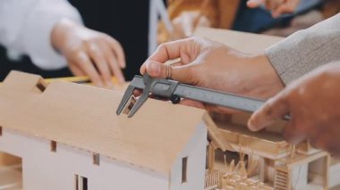 Marangoz ahşap bir modelle çalışıyor, ahşap bir ev.