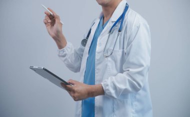 Tabletli olgun erkek doktor sunum yapıyor. İçerideki bulanık arkaplan.