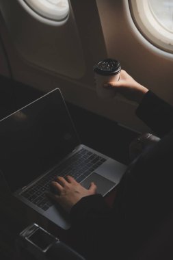 Sarışın kadın turist gelen bildirim netbook ile uçak koltuğunda oturan Smartphone cep telefonu ile kontrol. Genç işkadını paylaşmak medya telefonu dizüstü bilgisayar üzerinde uçak uçuş sırasında