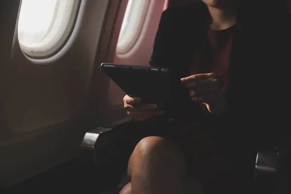 Sarışın kadın turist gelen bildirim netbook ile uçak koltuğunda oturan Smartphone cep telefonu ile kontrol. Genç işkadını paylaşmak medya telefonu dizüstü bilgisayar üzerinde uçak uçuş sırasında