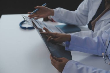 Doktor toplantı sırasında teşhisi tartışıyor. Bir grup doktor iş yerinde iş meselelerini tartışıyor. Tıbbi ekip hastayla tedavi seçeneklerini tartışıyor..