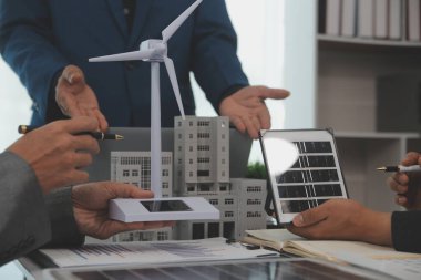 Mimarlar ve iş adamları, emlak sürdürülebilir yatırımları ve güneş enerjisi konut geliştirme projesi için zemin planı modifikasyonunu tartışıyor ve üzerinde kafa yoruyorlar.