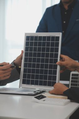 Mimarlar ve iş adamları, emlak sürdürülebilir yatırımları ve güneş enerjisi konut geliştirme projesi için zemin planı modifikasyonunu tartışıyor ve üzerinde kafa yoruyorlar.