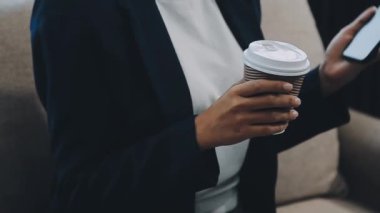 Kafedeki masada otururken akıllı telefon kullanan bir iş kadını.