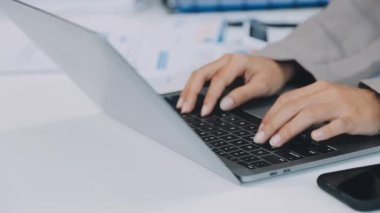 Genç iş adamı ofiste dizüstü bilgisayar kullanıyor..