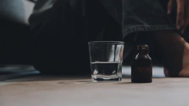 Sabahleyin elinde bir bardak su olan bir adam.