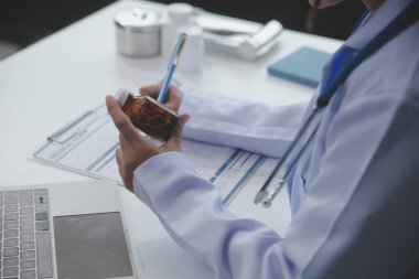 Beyaz önlüklü doktor elinde ilaç şişesiyle hastaya internetten ilaç yazıyormuş. Aile terapisti kaliteli ilaçlar öneriyor. Sağlık, tedavi kavramı