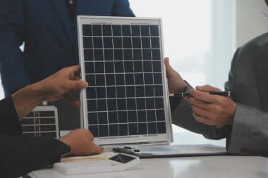 Mimarlar ve iş adamları, emlak sürdürülebilir yatırımları ve güneş enerjisi konut geliştirme projesi için zemin planı modifikasyonunu tartışıyor ve üzerinde kafa yoruyorlar.