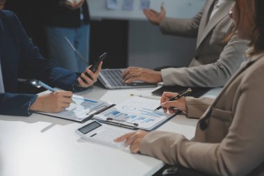 İş ekibi işbirliği mali veriler ve pazarlama büyüme raporlarıyla analiz etmeyi takım halinde, şirket kârından yararlanmak için strateji planlama, sunum ve beyin fırtınası grafiği üzerinde tartışır..