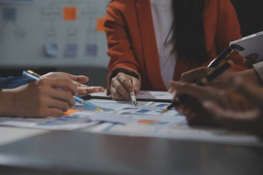 İş ekibi işbirliği mali veriler ve pazarlama büyüme raporlarıyla analiz etmeyi takım halinde, şirket kârından yararlanmak için strateji planlama, sunum ve beyin fırtınası grafiği üzerinde tartışır..