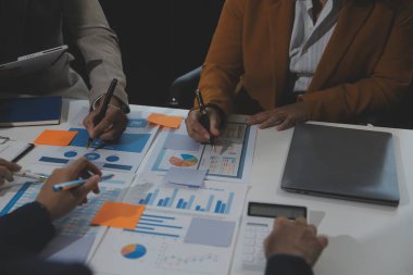 İş ekibi işbirliği mali veriler ve pazarlama büyüme raporlarıyla analiz etmeyi takım halinde, şirket kârından yararlanmak için strateji planlama, sunum ve beyin fırtınası grafiği üzerinde tartışır..