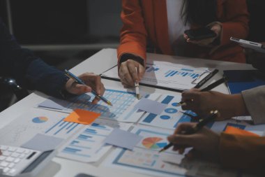 İş ekibi işbirliği mali veriler ve pazarlama büyüme raporlarıyla analiz etmeyi takım halinde, şirket kârından yararlanmak için strateji planlama, sunum ve beyin fırtınası grafiği üzerinde tartışır..