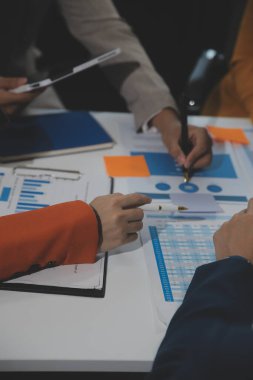 İş ekibi işbirliği mali veriler ve pazarlama büyüme raporlarıyla analiz etmeyi takım halinde, şirket kârından yararlanmak için strateji planlama, sunum ve beyin fırtınası grafiği üzerinde tartışır..