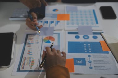 İş ekibi işbirliği mali veriler ve pazarlama büyüme raporlarıyla analiz etmeyi takım halinde, şirket kârından yararlanmak için strateji planlama, sunum ve beyin fırtınası grafiği üzerinde tartışır..