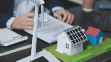 İş adamları rüzgar türbiniyle çalışıyor.