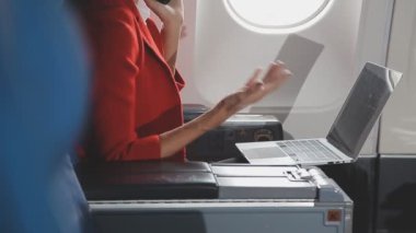Uçakta dizüstü bilgisayar kullanan iş kadını