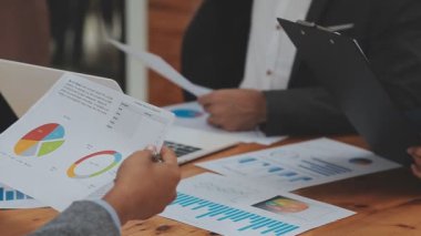 Ofiste yeni çizelgeleri ve mali grafikleri tartışan iş ekibinin görüşünü kapatın.