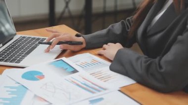 İş kadını el bilgisayarı ve tablet bilgisayarla mali raporla birlikte çalışıyor.