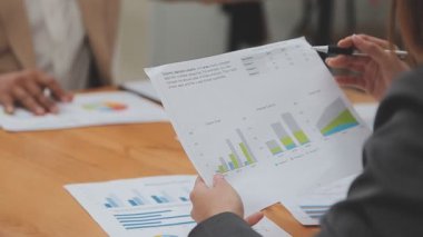 İş ekibi masaüstünde mali verileri tartışıyor.