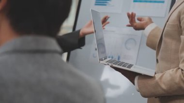 İş ekibi dizüstü bilgisayarda finansal verileri tartışıyor.