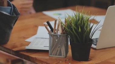 Masada dizüstü bilgisayar ve kahveyle çalışan genç adam.