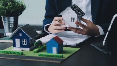 Emlakçı ev modelini ve modelini ev almak için gösteriyor. Emlak kredisi kavramı.