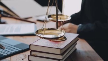 Yargıç tokmak ve avukat adalet belgeleri ve dizüstü bilgisayarla masada çalışıyor.