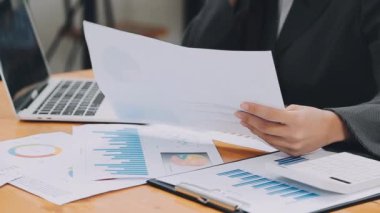 İş kadını ofisteki dizüstü bilgisayardaki finansal verileri analiz ediyor..