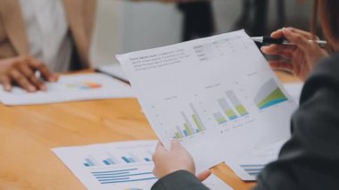 İş adamı masadaki mali grafiği tartışıyor.