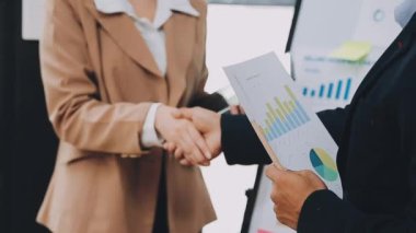 İş adamları modern ofiste finansal verileri tartışıyor ve analiz ediyorlar.