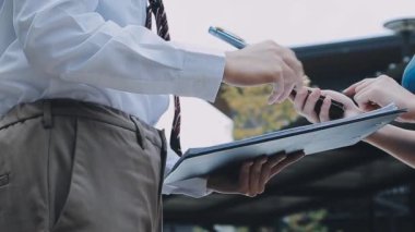 Yakın plan - Modern ofiste dururken dijital tablet tutan ve notlar yazan iş kadını