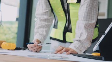 Ofiste inşaat projesinde çalışan mühendis ya da mimar mühendisi. İnşaat ve mühendislik teması.