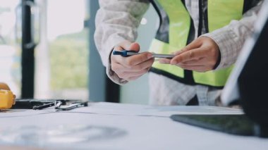 Genç Asyalı mühendis ya da mühendis ofiste dizüstü bilgisayar ve tablet bilgisayarla ya da sanayi şantiyesinde çalışan mühendis ya da mühendis, mühendislik kavramı, endüstriyel yapı kavramı