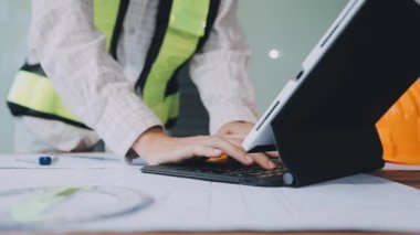 Ofis inşaatında dizüstü bilgisayarı ve planları olan mühendis mühendis mimar. mühendislik kavramı.