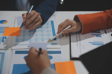 İş ekibi işbirliği mali veriler ve pazarlama büyüme raporlarıyla analiz etmeyi takım halinde, şirket kârından yararlanmak için strateji planlama, sunum ve beyin fırtınası grafiği üzerinde tartışır..