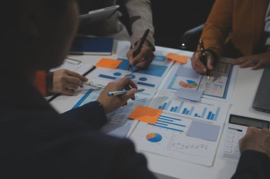 İş ekibi işbirliği mali veriler ve pazarlama büyüme raporlarıyla analiz etmeyi takım halinde, şirket kârından yararlanmak için strateji planlama, sunum ve beyin fırtınası grafiği üzerinde tartışır..